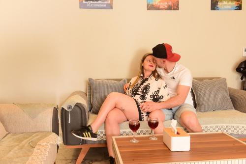 a man and a woman sitting on a couch at Farida Habu Palace Hotel luxor in Al Aqālitah