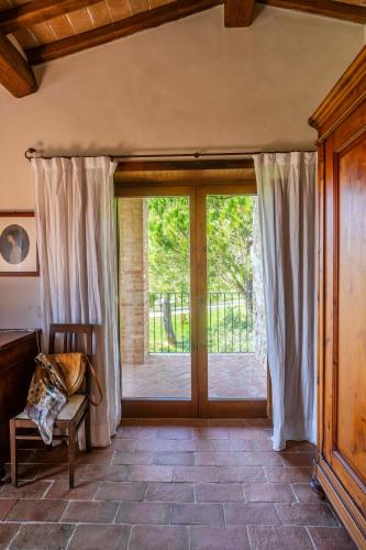 a room with a sliding glass door with a window at Agriturismo Sole in Trequanda