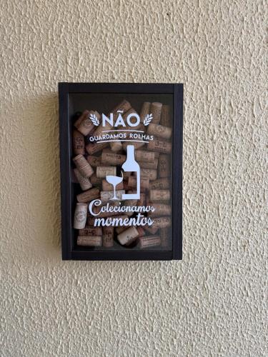 a picture of a frame on a wall with wine bottles at Térreo, sem escadas, com WI-FI, a 15 minutos do centro in Brasilia