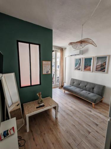 un salon avec un canapé et une table dans l'établissement Appartement cosy - hypercentre au calme - patio, à Nice