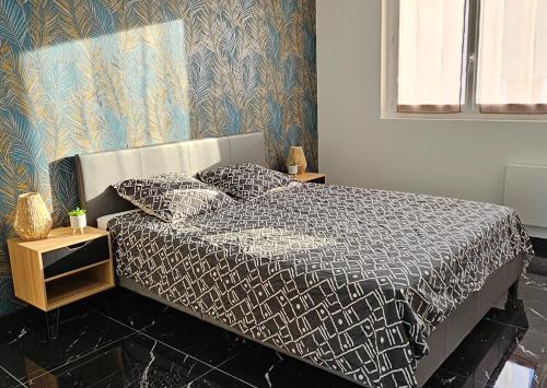 une chambre avec un lit avec une couette noire et blanche dans l'établissement Appartement et son jacuzzi, à Saint-Cézaire-sur-Siagne