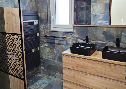 - une salle de bains avec deux lavabos sur un comptoir en bois dans l'établissement Appartement et son jacuzzi, à Saint-Cézaire-sur-Siagne