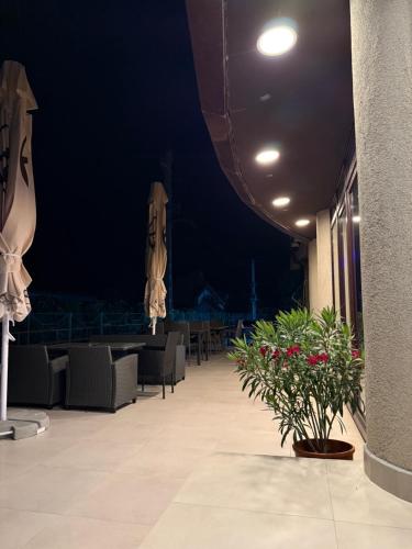 a building with tables and chairs and umbrellas at night at Vila Premiere Bistro-Spa in Piatra Neamţ