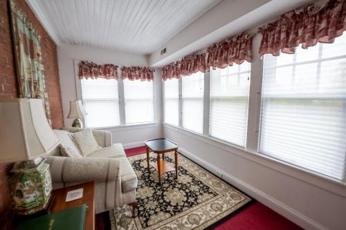 a living room with windows and a couch and a table at Antrim 1844 in Taneytown