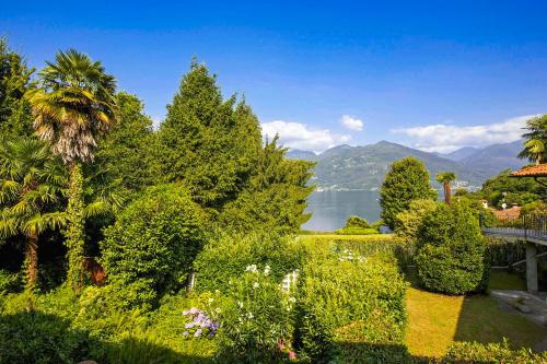 un jardín con vistas al lago y a las montañas en Casa Magnolia, en Luino