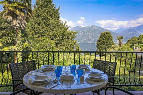 una mesa con platos y cubiertos en el balcón en Casa Magnolia, en Luino