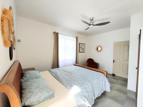 a bedroom with a bed and a ceiling fan at Noulakaz, séjour paisible à 10 min de Belle Mare in Argy