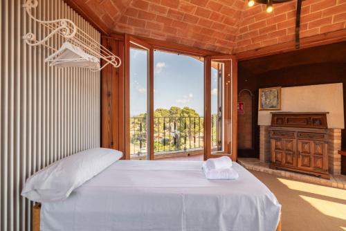 RíudecañasにあるVilla La Guaitaのベッドと大きな窓のある寝室