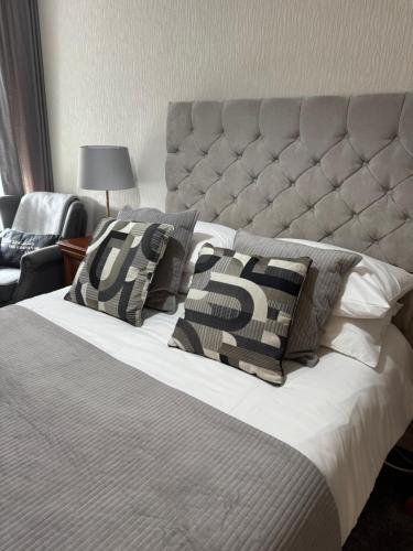 a bedroom with a large bed with pillows on it at The Crescent in Dundee