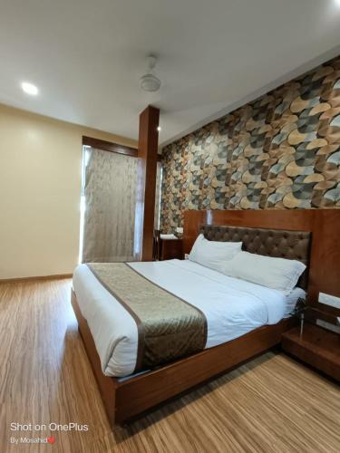 a bedroom with a bed and a stone wall at Arton By Hotel Avion Palace - Near International Airport in Mumbai