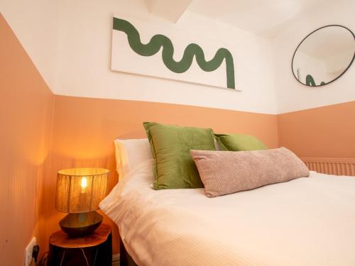 a bedroom with a bed with green pillows at Stylish Steep Hill Apartment Pass the Keys in Lincoln