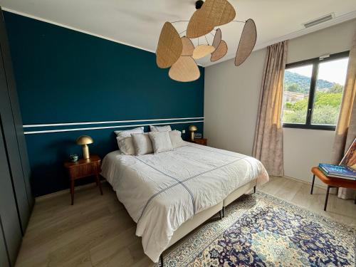 a bedroom with a large bed with a blue wall at Appartement standing grande terrasse vue mer in Monticello