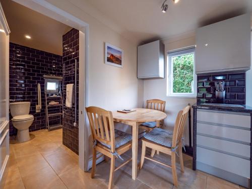 una cucina con tavolo e sedie e un bagno di One bedroom bungalow with private garden at Parkland, near Kingsbridge a Kingsbridge