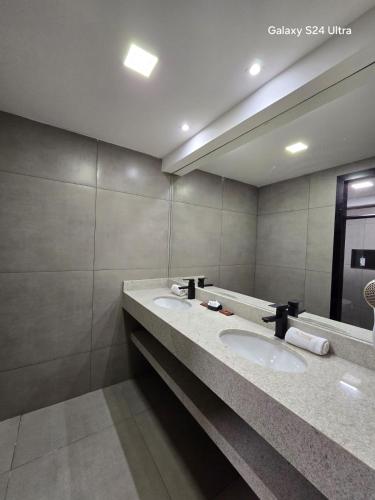 a bathroom with two sinks and a large mirror at Village Iguassu Hotel in Foz do Iguaçu