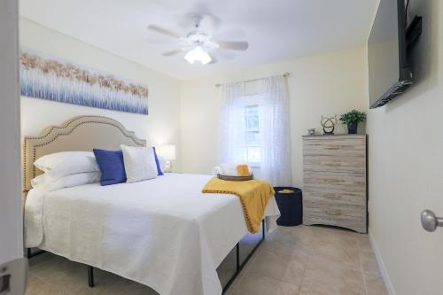 une chambre avec un lit blanc et une commode dans l'établissement Cozy 2 Bed Room Apartment By Armature Works River Walk, à Tampa