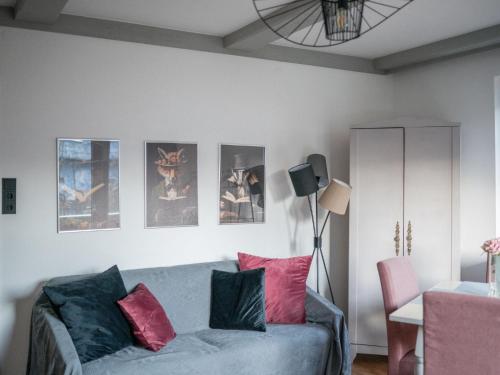 een woonkamer met een bank en wat foto's aan de muur bij Apartment Anny 2 by Interhome in Zell am See