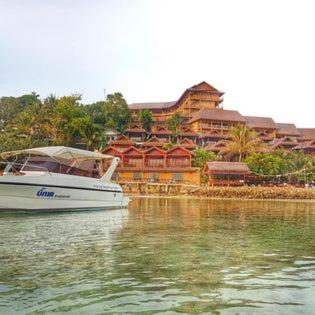 a boat in the water in front of a building at Haad Yao Bayview Resort in Haad Yao