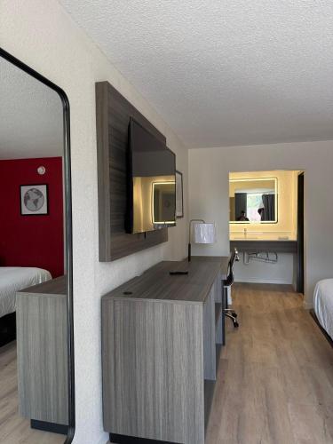 a hotel room with a desk and a mirror at Travelodge by Wyndham Lumberton in Lumberton