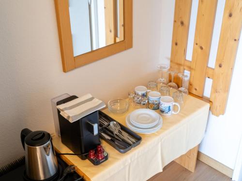 a table with cups and plates and a coffee maker at Apartment Penthouse Deluxe Galerie 2 stöckig by Interhome in Strobl