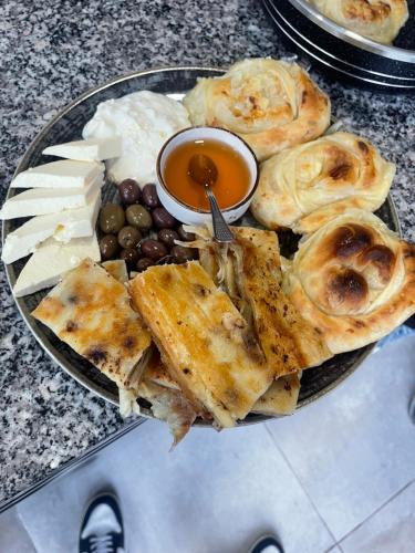 a plate of food with pies and olives and dips at Two Brothers B A&S Hotel Bar & Restaurant in Valbonë