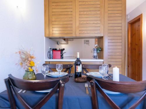 tavolo da pranzo con bottiglia di vino e bicchieri di Apartment Les Dryades 6 by Interhome a Villars-sur-Ollon