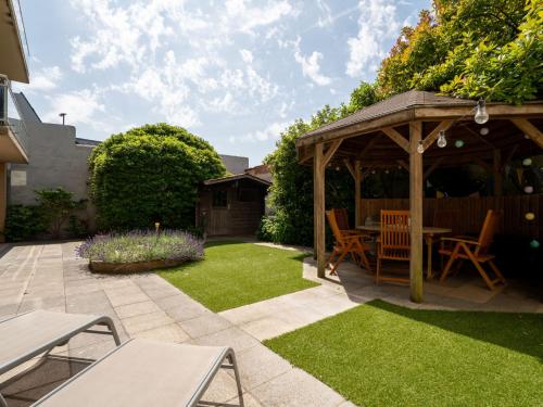 a garden with a wooden gazebo and grass at Apartment Leonifi by Interhome in Bredene