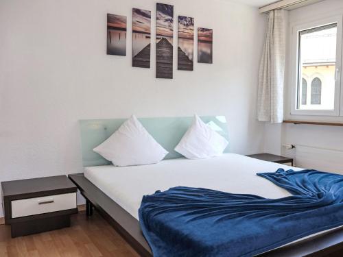 a bedroom with a bed with a blue blanket at Apartment Rubin by Interhome in Zermatt