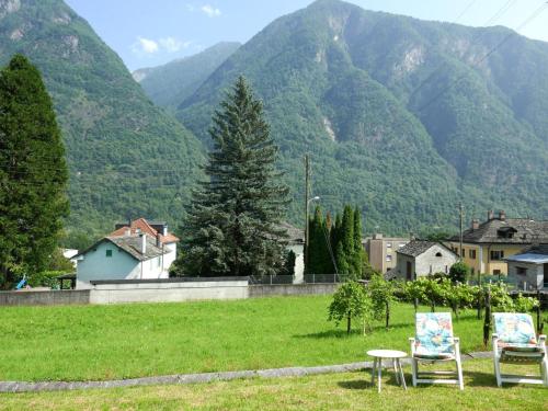 two chairs in a field with mountains in the background at Holiday Home Casa Calanca by Interhome in Grono