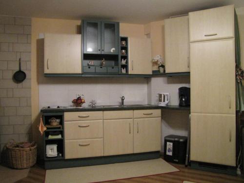 a kitchen with white cabinets and a white refrigerator at Stollenklause in Hormersdorf