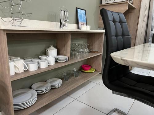 a kitchen with a counter with plates and a chair at Bay Ridge Luxury Apartment, Ballito in Ballito