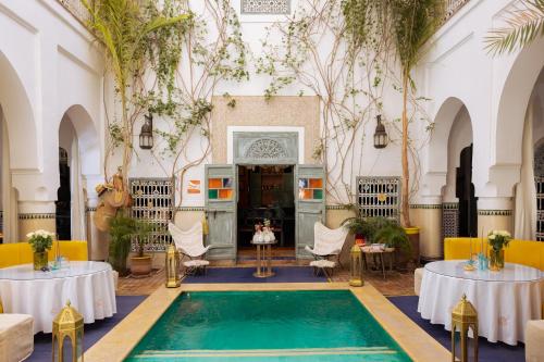 マラケシュにあるRiad Dar Al Assadのテーブル2台と椅子が備わる客室内のプールを利用できます。