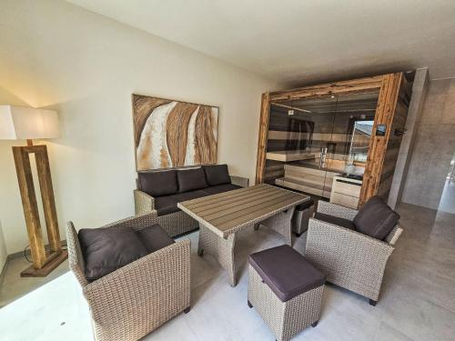 a living room with wicker furniture and a table and chairs at Chalet Ossiacher See Chalet 1 by Interhome in Bodensdorf