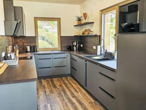 a kitchen with stainless steel appliances and a wooden floor at Chalet Ossiacher See Chalet 1 by Interhome in Bodensdorf
