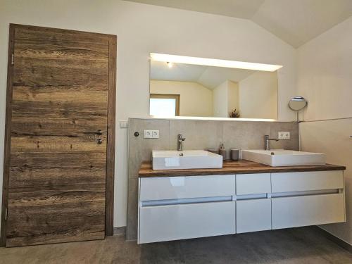 a bathroom with two sinks and a mirror at Chalet Ossiacher See Chalet 1 by Interhome in Bodensdorf