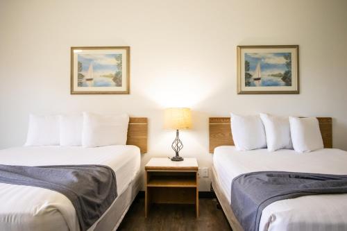 a hotel room with two beds and a lamp at The Tillamook Inn in Tillamook