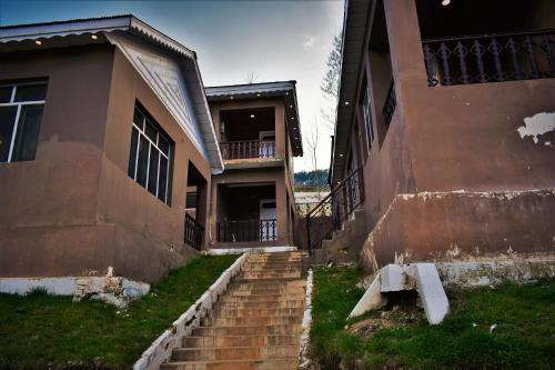 an old house with stairs leading to a building at Forest Valley Cottages Kalam by Khan Familia Travels in Kalām