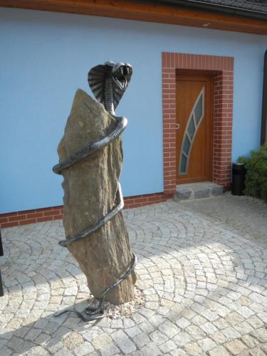 a statue of a bird perched on a rock at Penzion U Hada in Velké Pavlovice