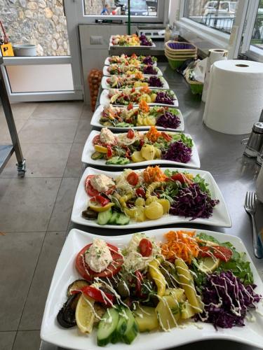 a row of plates of food on a table at Two Brothers B A&S Hotel Bar & Restaurant in Valbonë