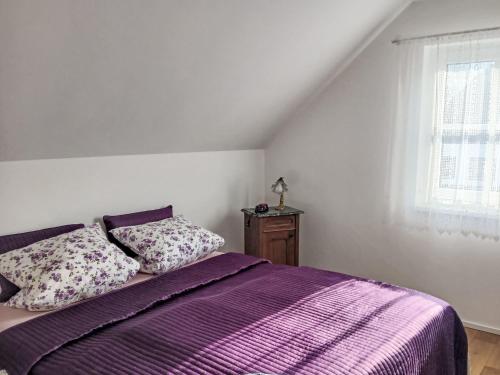 a bedroom with a purple bed and a window at Holiday Home Casa Lenka by Interhome in Zlaté Hory