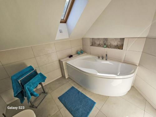 a large white tub in a bathroom with blue towels at Holiday Home Casa Lenka by Interhome in Zlaté Hory