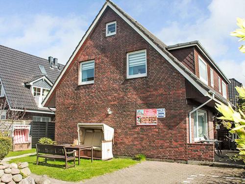 a brick house with a bench in front of it at Apartment Fewo 1 in ruhigem Haus by Interhome in Süderende