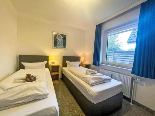 two beds in a room with a teddy bear on the bed at Apartment Fewo 1 in ruhigem Haus by Interhome in Süderende