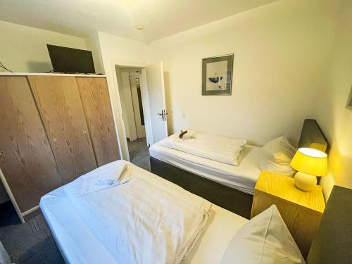 a hotel room with two beds and a television at Apartment Fewo 1 in ruhigem Haus by Interhome in Süderende
