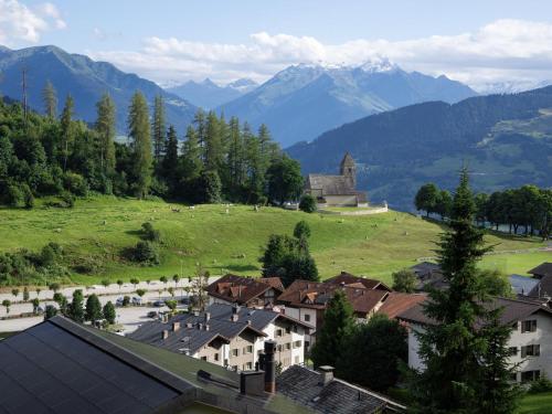 a village in the mountains with a church on a hill at Apartment La Siala Apt-56A by Interhome in Falera