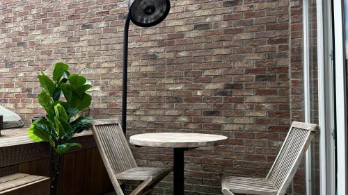 a table and two chairs next to a brick wall at Le Theux Toit - Escapade romantique et Wellness in Theux