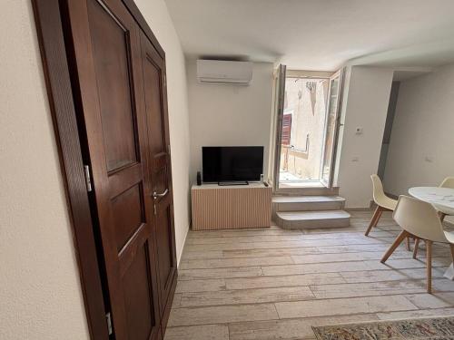 a room with a door and a table and a television at Casa Annalisa - Pesaro Center in Pesaro