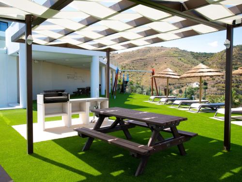 a picnic table and bench under a pavilion at Apartment Collection View Free Spa & Padel by Interhome in Torrox Costa