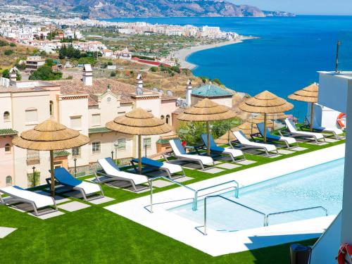 a view of the pool at a resort with chairs and umbrellas at Apartment Collection View Free Spa & Padel by Interhome in Torrox Costa