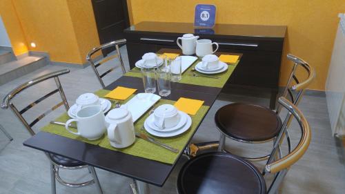 una mesa negra con sillas y platos blancos. en Hotel La Encina Celorio Llanes en Llanes