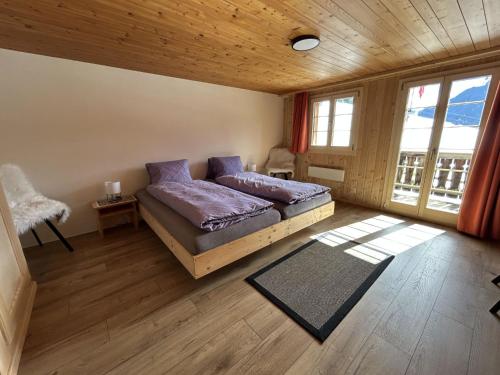 a bedroom with a bed with purple pillows at Apartment Alpenchalet Haldeli by Interhome in Gstaad